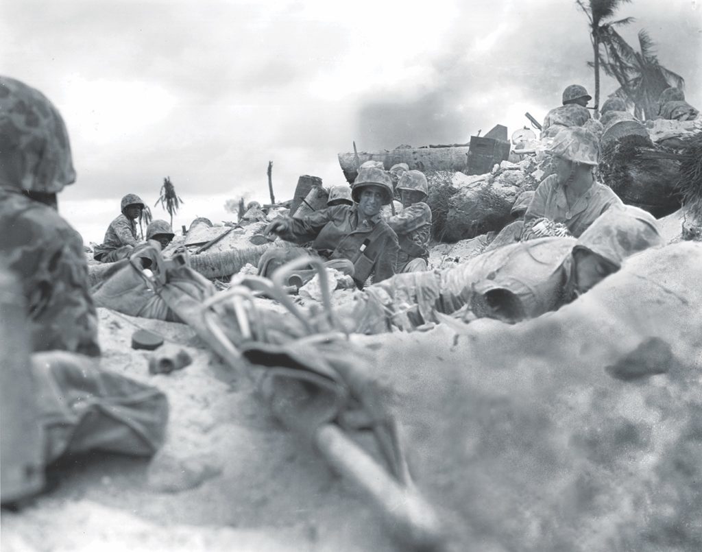 U.S. Marines on Tarawa seek cover alongside a fallen comrade. (National Archives)