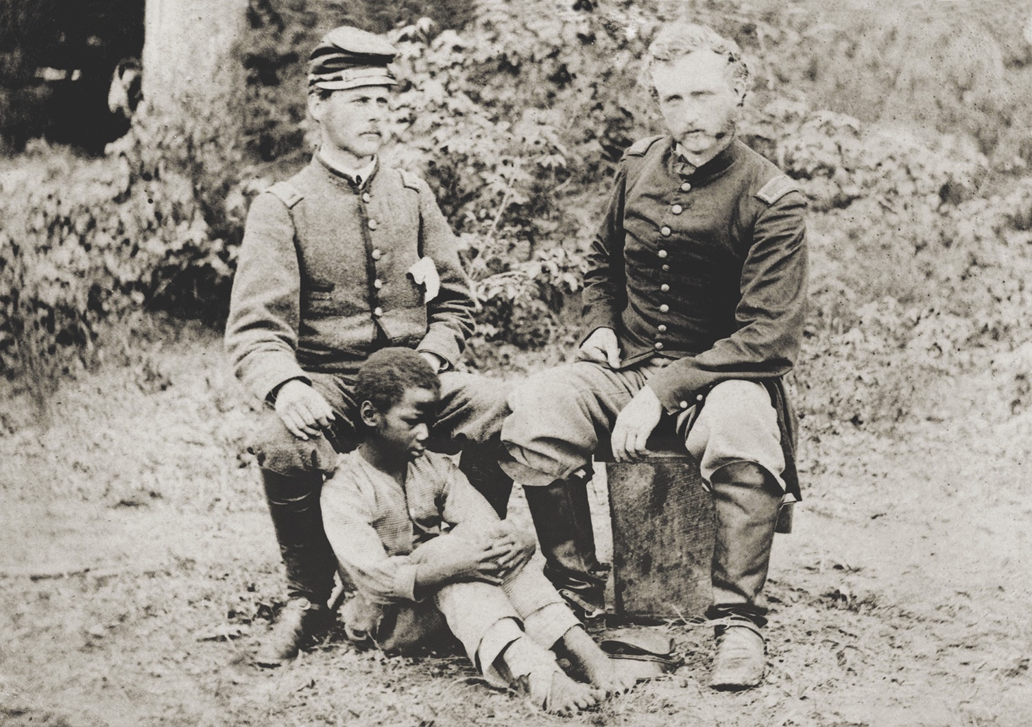 In this Peninsula image of captured Confederate Lieutenant J.B. Washington and his friend, Captain George Custer, the unknown African American boy is often overlooked. But his presence speaks to evolving war aims. (National Archives)