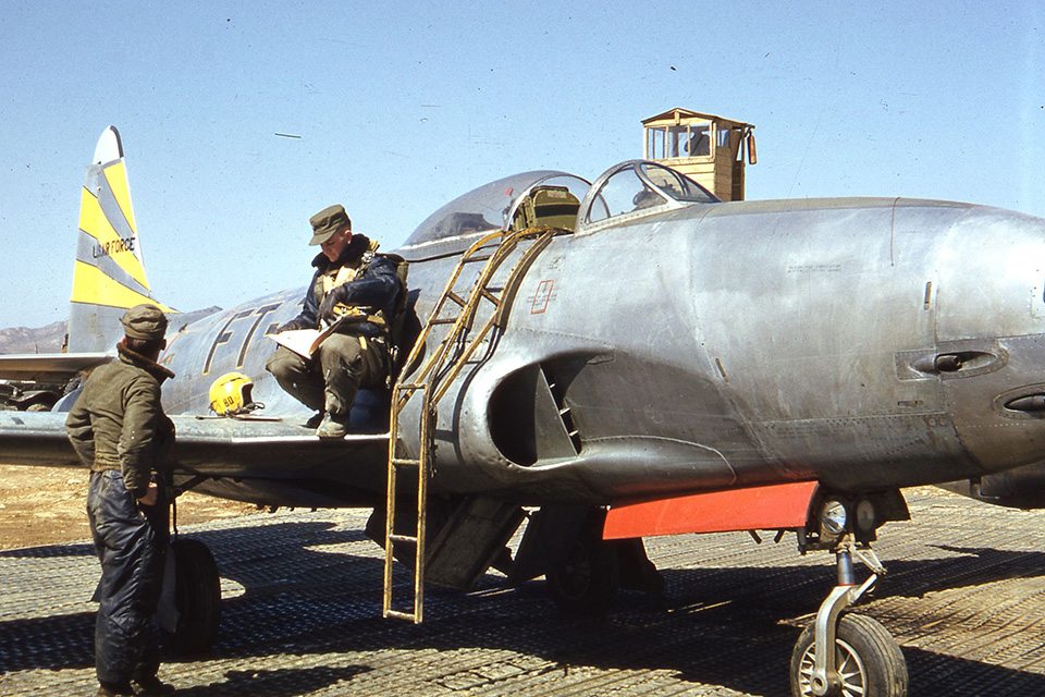 Ground crewmen load a 500-pound bomb onto the wing of an 80th Fighter-Bomber Squadron F-80C in Korea. (U.S. Air Force)