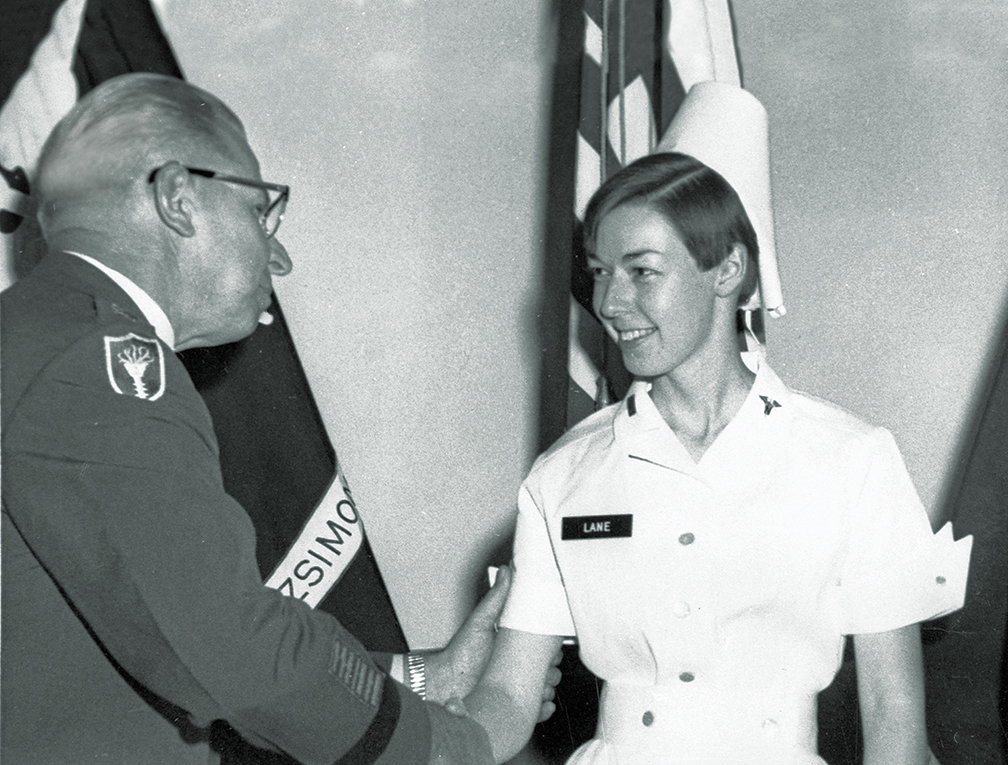 In this Aug. 30, 1968, photo provided by Philip Bigler, author of Hostile Fire, U.S. Army nurse Sharon Lane is congratulated by a military official as she's promoted to first lieutenant in Aurora, Colo. Lane, the only American servicewoman killed by hostile fire in the Vietnam War, has been immortalized in books, statues and a television show, and veterans still gather at her grave five decades after her death. (U.S. Army/Hostile Fire/Vandamere Press via AP)
