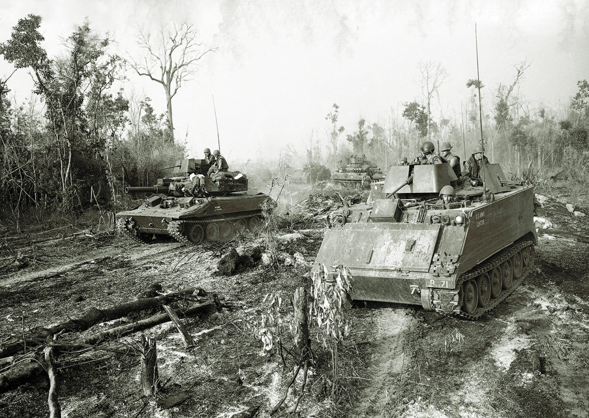 Armored Personnel Carriers with troops of the 11th Armored Cavalry Regiment aboard grind their way through underbrush in Tay Ninh Province, about a mile and a half away from the Cambodian border on March 18, 1970, as they proceed towards an enemy base camp. The troops were checking the area to determine effectiveness of a recent B-52 bomber strike on the base camp. (AP Photo/Charles Ryan)