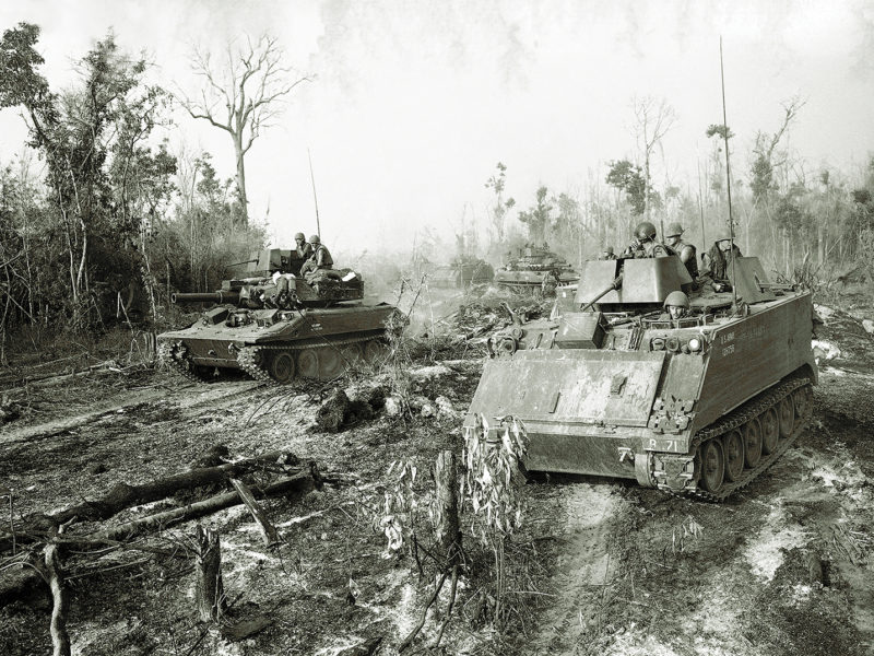 Armored Personnel Carriers with troops of the 11th Armored Cavalry Regiment aboard grind their way through underbrush in Tay Ninh Province, about a mile and a half away from the Cambodian border on March 18, 1970, as they proceed towards an enemy base camp. The troops were checking the area to determine effectiveness of a recent B-52 bomber strike on the base camp. (AP Photo/Charles Ryan)