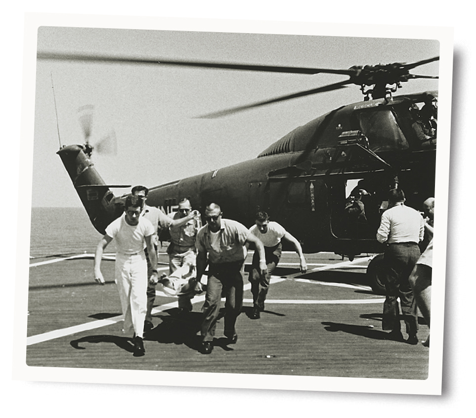 Photo of Medical assistants unload a wounded man from a rescue helicopter onto the Repose in 1966.