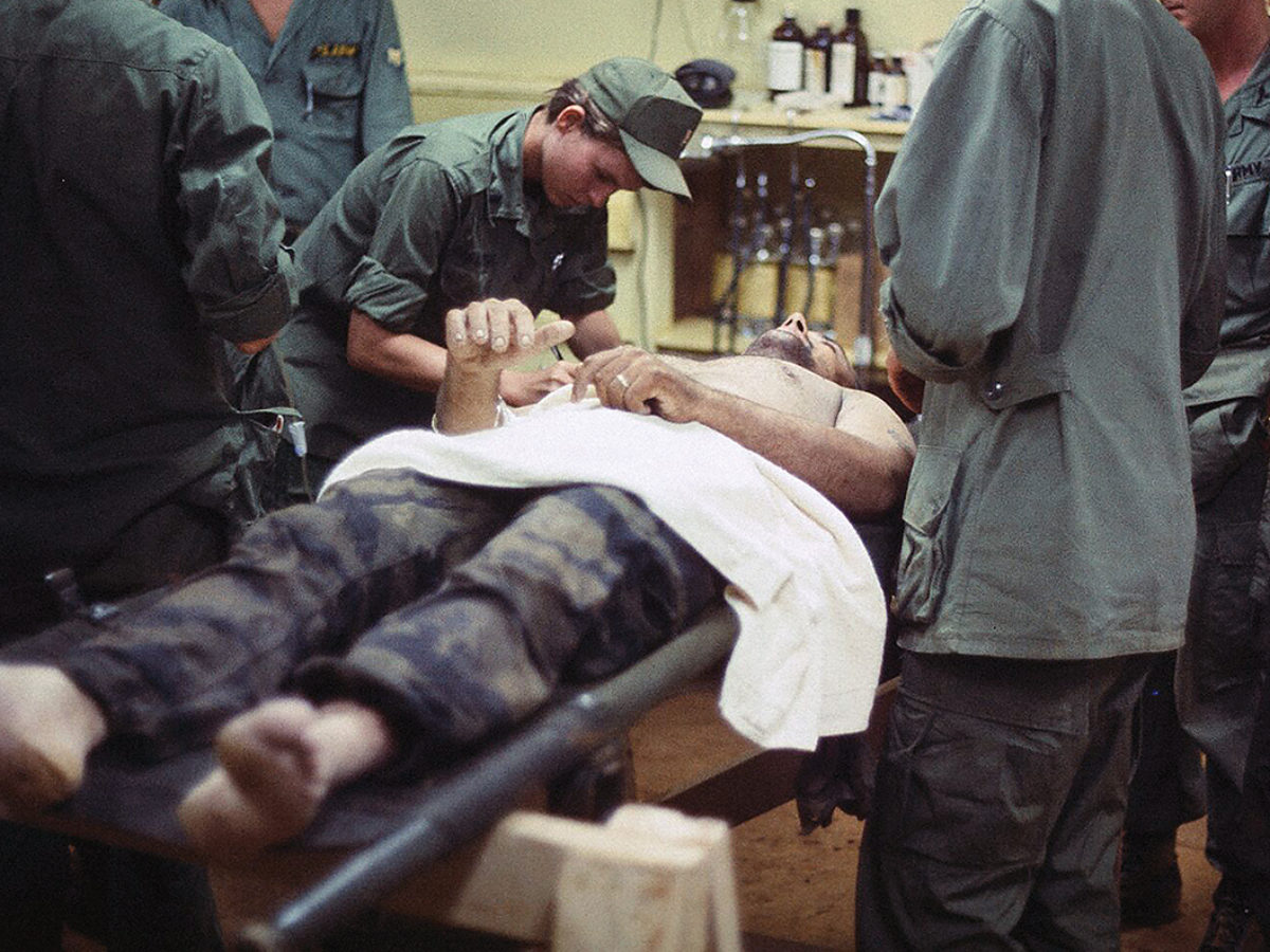 A nurse helps prepare a patient for an operation at the 7th Surgical Hospital, a mobile army surgical hospital (MASH), at Blackhorse base camp near Saigon in 1968. Nurses were among the earliest U.S. service members to arrive in Vietnam.