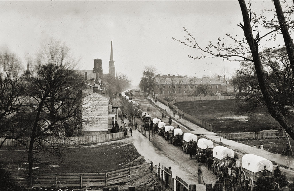 Petersburg, Va. The first Federal wagon train entering the town.. Image shot 1865. Exact date unknown.