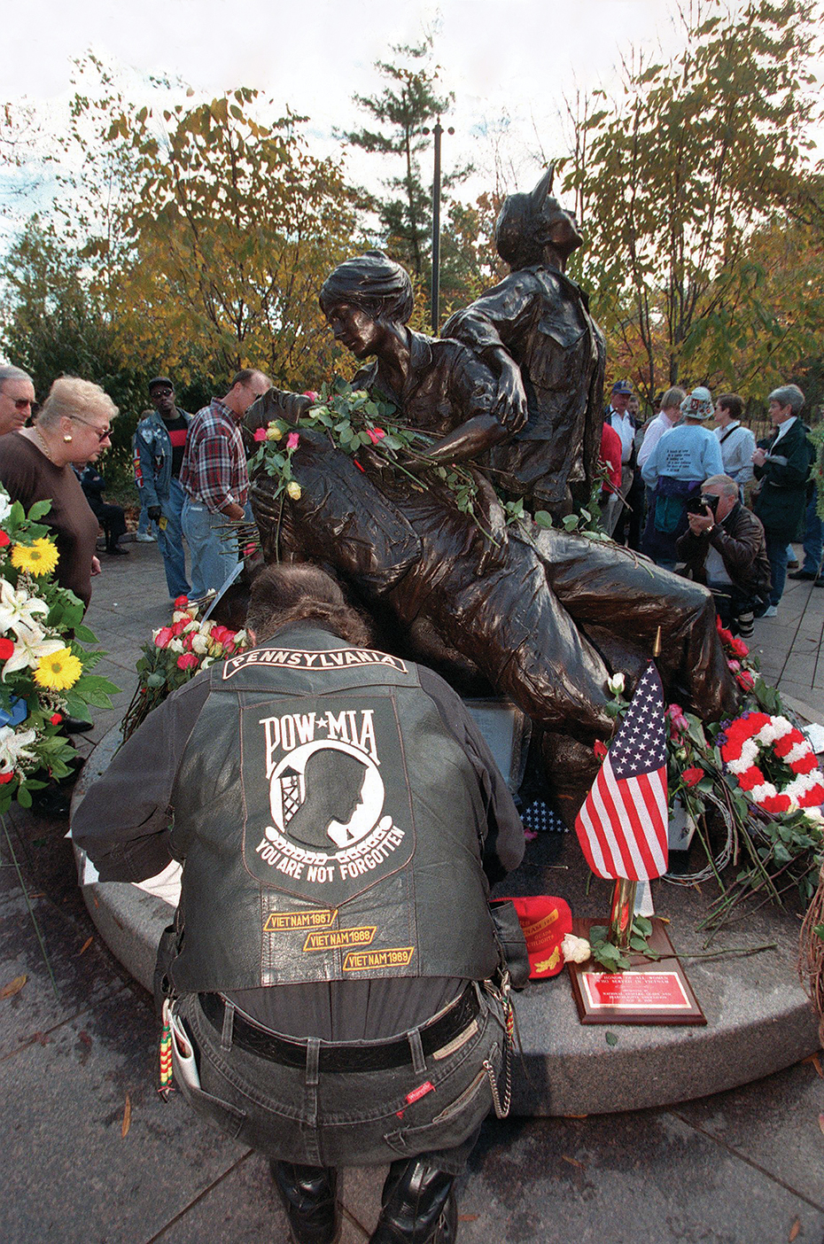 Photo of WASHINGTON, : An unidentified visitor to the Vietnam Women's Memorial lays flowers in tribute to their service during Veteran's Day observances in Washington, DC 11 November. US President Bill Clinton hosted ceremonies at Arlington National Cemetery. AFP PHOTO Luke FRAZZA (Photo credit should read LUKE FRAZZA/AFP via Getty Images)