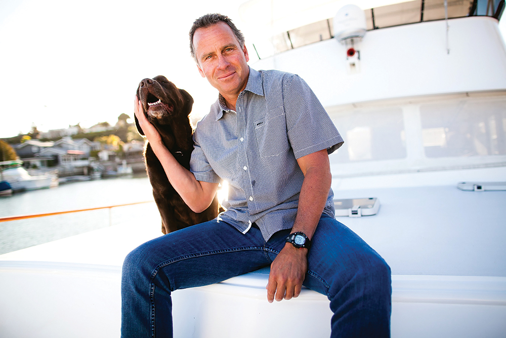 Ethan Wayne today posing with his dog aboard his boat