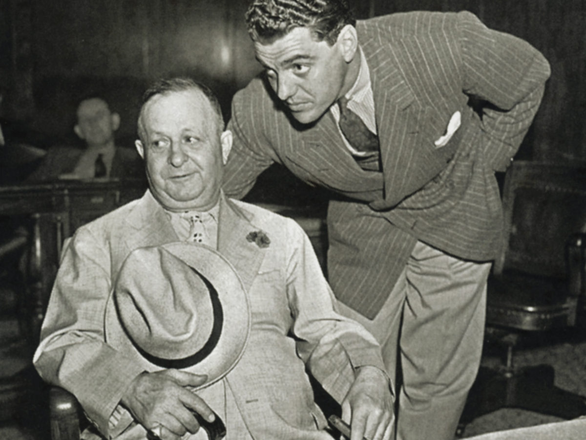 Bernstein, seated, in a New York court in 1938 with lawyer Greg Bautzer to answer charges of kiting checks.