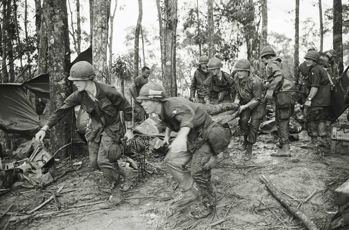 5/18/1969-A Shau Valley, South Vietnam: A quartet of U.S. 101st Air Division troopers keep low as they rush a stretcher-borne wounded comrade to a medical aid station during the battle for Hamburger Hill. New fighting erupted about the controversial hill on May 23.