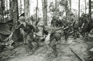 5/18/1969-A Shau Valley, South Vietnam: A quartet of U.S. 101st Air Division troopers keep low as they rush a stretcher-borne wounded comrade to a medical aid station during the battle for Hamburger Hill. New fighting erupted about the controversial hill on May 23.