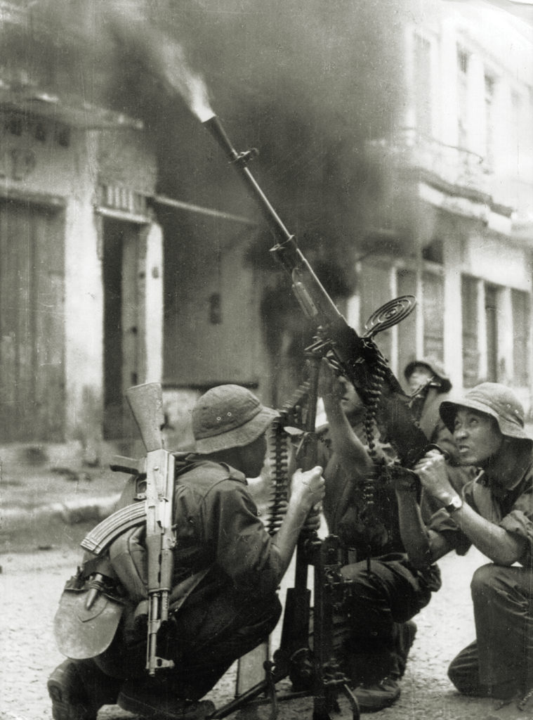 Photo of Viet Cong troops firing a 12.7 mm DShK machine gun at U.S. aircraft during an air raid on a South Vietnamese village.