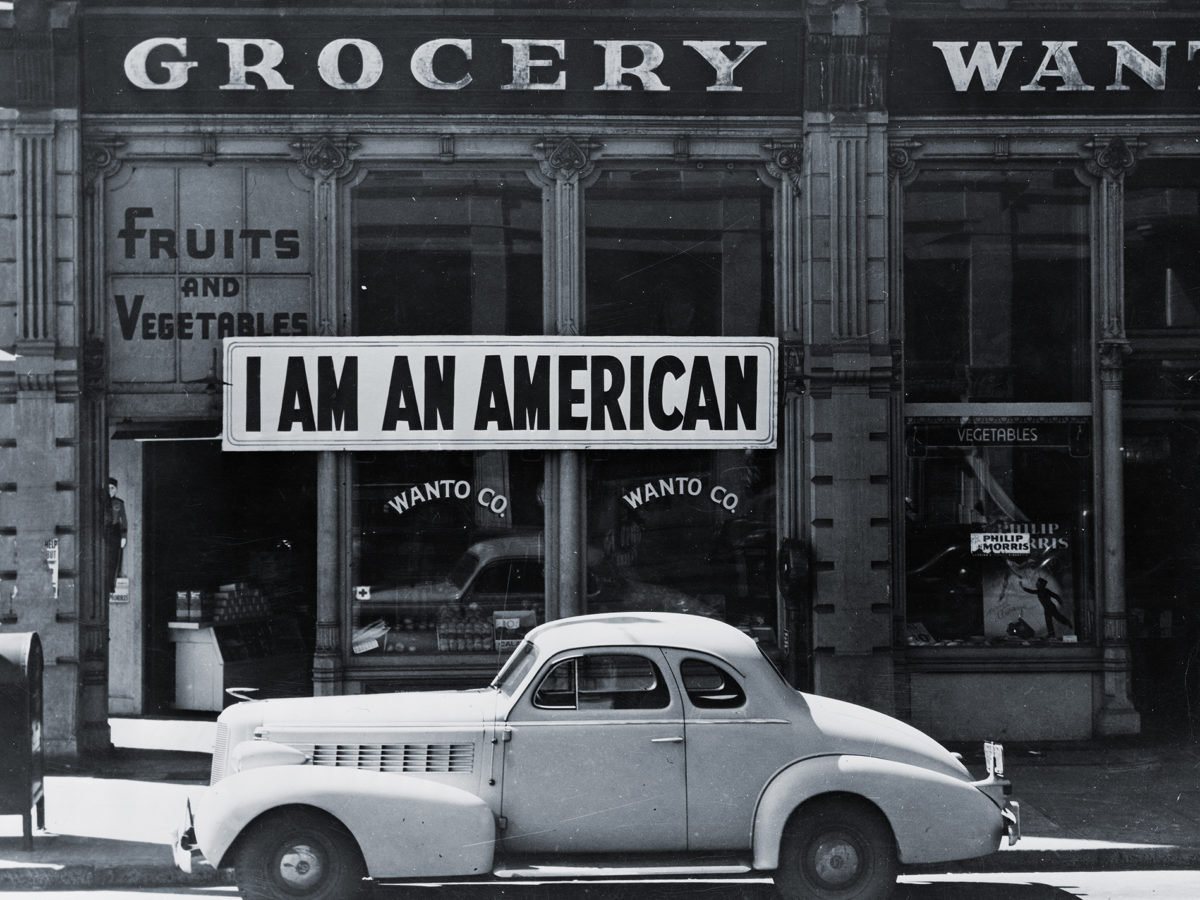 Photo of Store front with "I am an American" sign in window