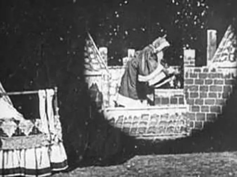 Santa prepares to descend a chimney in this still from Santa Claus (1898).