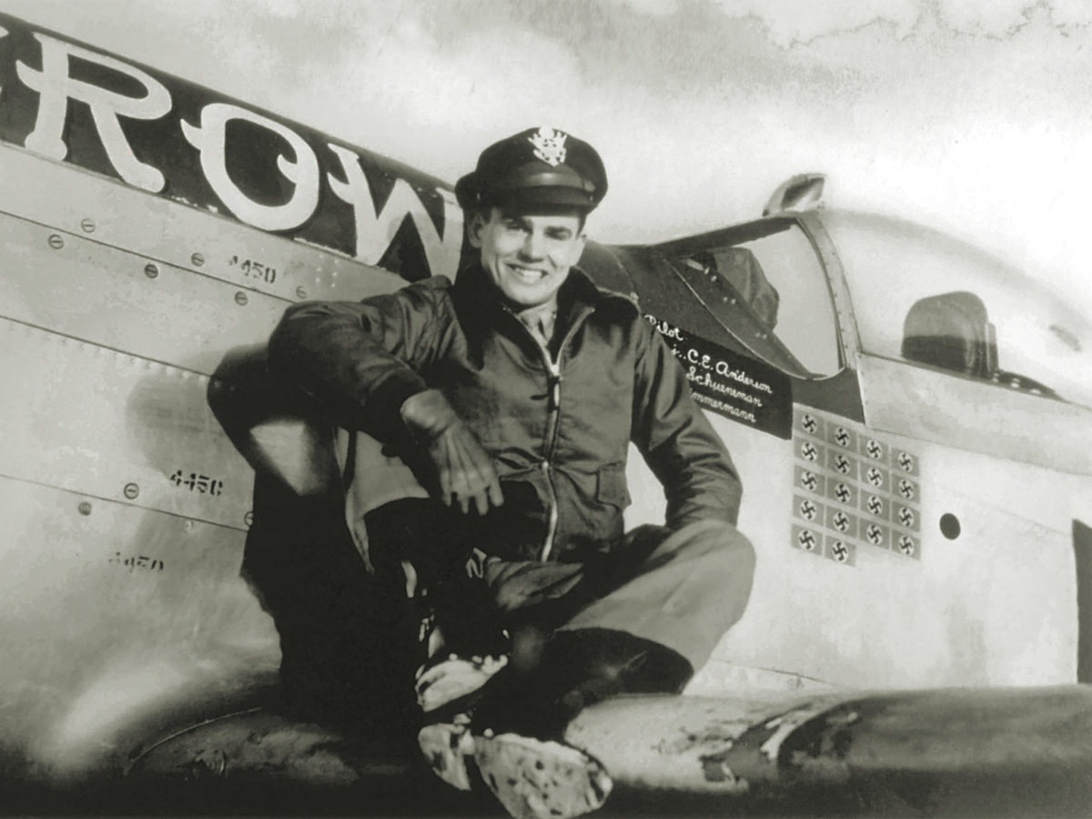 Photo of Major Bud Anderson poses in 1944 on the wing of his P-51D Mustang Old Crow, the victory markings beneath its canopy reflecting his status as a triple ace.