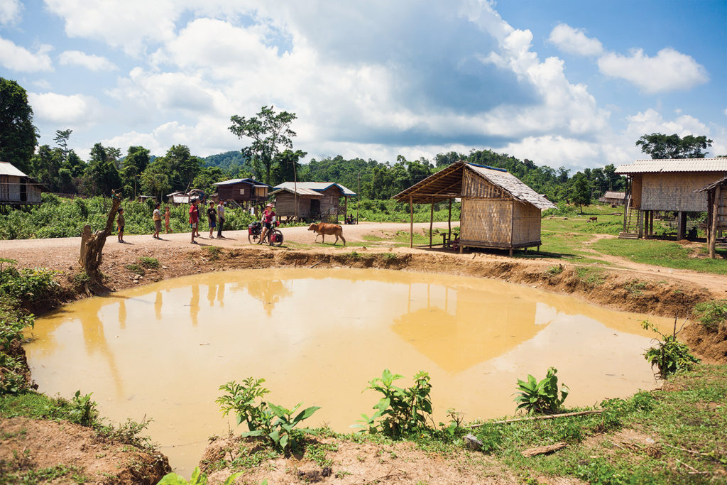 Photo of a bomb crater in a village. Former Ho Chi Minh Trail, Khammouane Province, Laos.