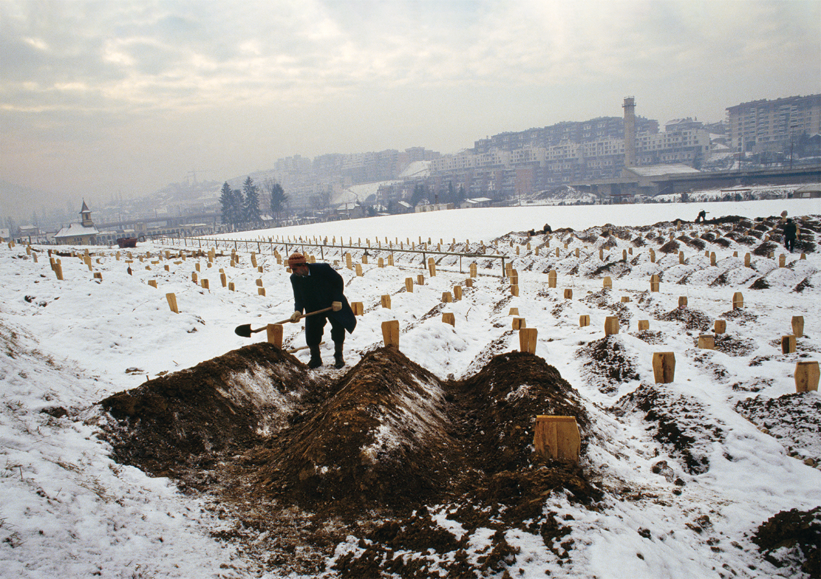 Photo of a gravedigger burying the bodies of civilians killed during the siege of Sarajevo in the Yugoslavian Civil War.