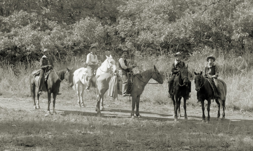 Actors on horseback in movie scene