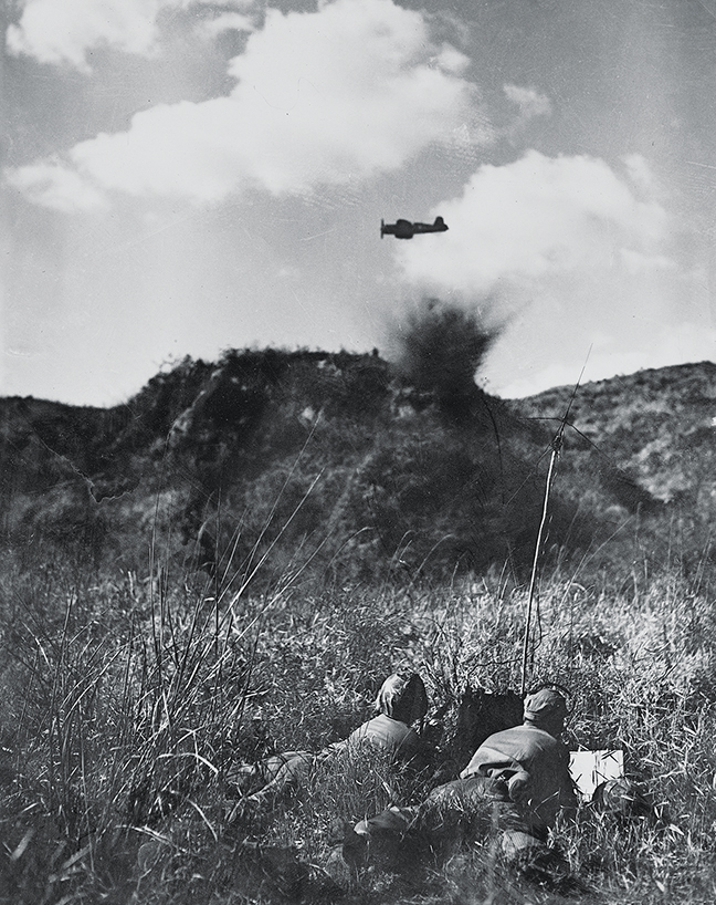 Photo of showing Cooperating with radio-equipped forward combat controllers, a Vought F4U-4 Corsair bombs an enemy bunker in Korea on Aug. 19, 1952.