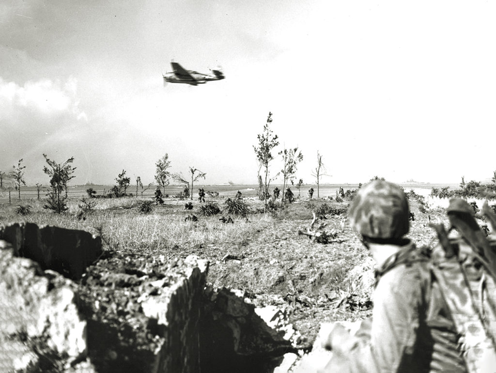Photo of a Eastern Aircraft TBM-1 spearheads a Marine assault on a hidden Japanese strongpoint on Okinawa on April 1, 1945.