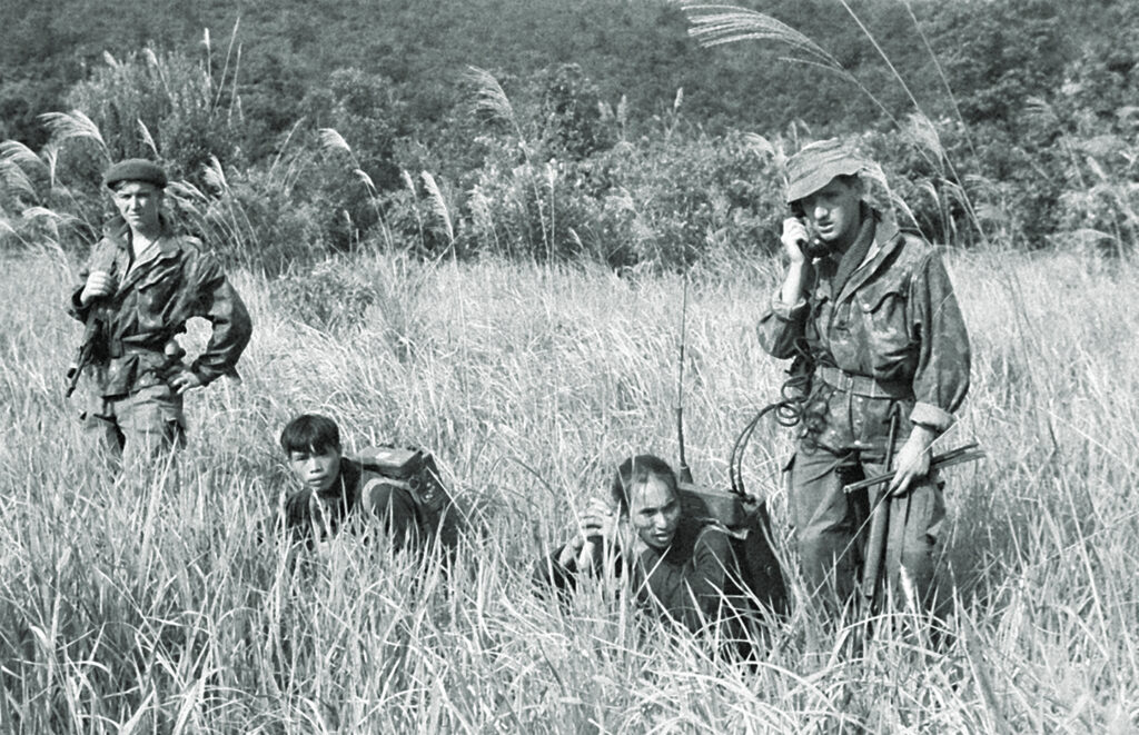 Photo of captured Viet Minh troops forced by French soldiers to carry radio equipment.