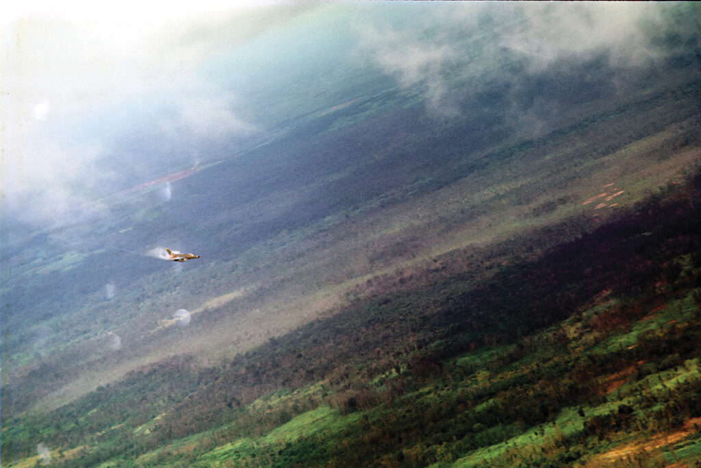 Photo of a F-100 Super Sabre, call sign Yellow Jacket 11, releases its bomb load over a designated target area in September 1969.