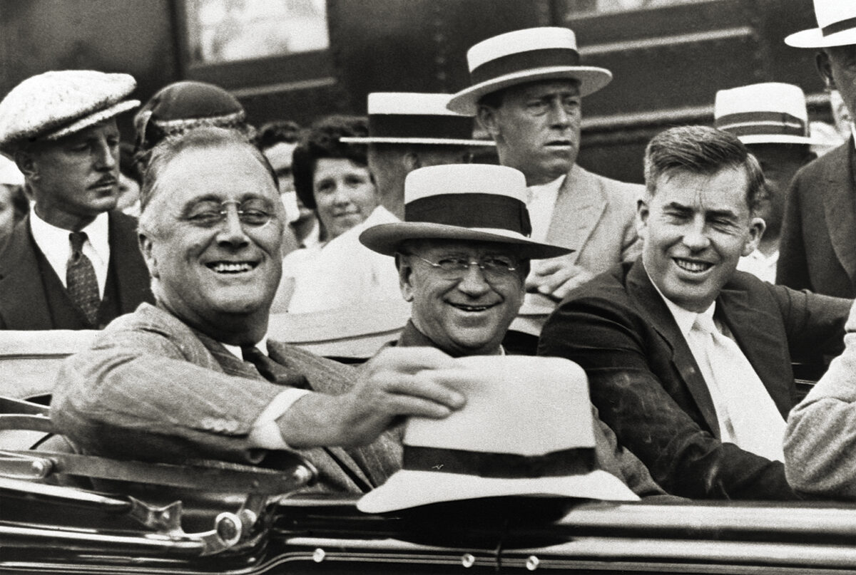 Photo of US President Franklin D. Roosevelt (left) rides in an automobile with Secretary of the Interior Harold L. Ickes (center), and Secretary of Agriculture Henry A. Wallace (right). The photo was taken in August of 1933, at the beginning of the New Deal administration.