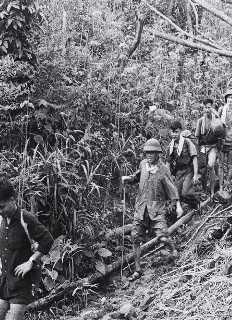 Photo of Brigadier General Chu Huy Man (in the helmet), architect of the North Vietnamese campaign in the Ia Drang Valley, moves through the Central Highlands with his men later in the war.