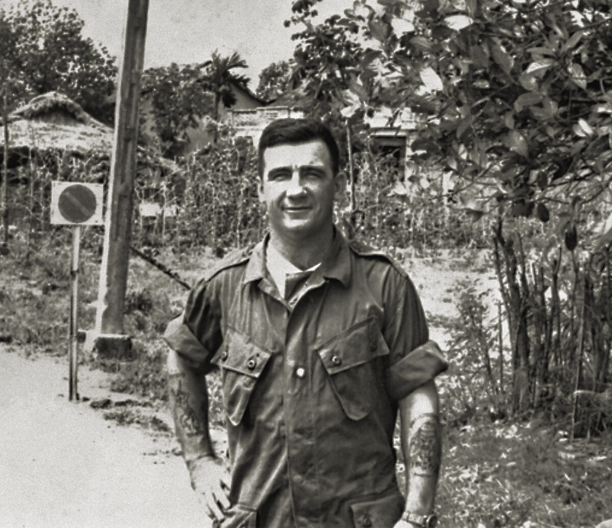 Photo of Warrant Officer Class II, (WO2), Kevin (Dasher) Arthur Wheatley VC, a member of the Australian Army Training Team, Vietnam, (AATTV) standing on the roadside near Saigon. WO2 Wheatley was awarded a Victoria Cross (VC) posthumously for action against the Viet Cong. He moved a wounded soldier, WO2 R. J. Swanton, from the open paddy fields into a wooded area and remained with him knowing the Viet Cong were moving in on their position.
