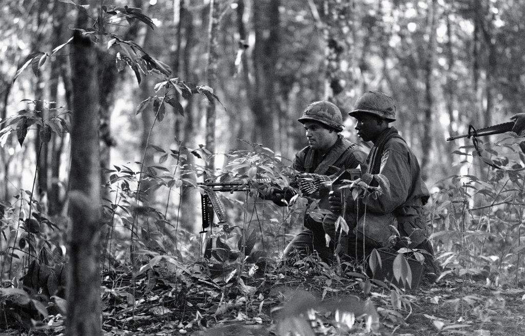 Photo of an American machinegun crew firing point-blank into Communist ring around Bu Dop after an infantry patrol ran into the enemy lines at edge of the Special Forces camp runway in Vietnam on Dec. 1, 1967. A large communist force encircled the tiny outpost near the Cambodian border.