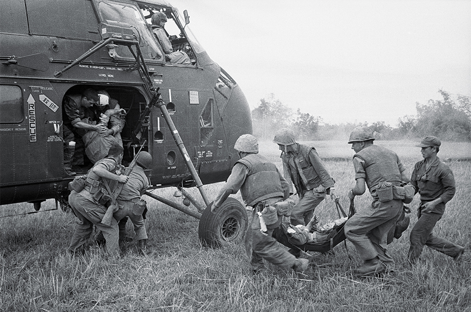 Photo of U.S. Marines rushing wounded comrades to a waiting evacuation chopper during the last day of the sweeping operation, which netted more than 600 Viet Cong dead, near the Chu Lai airfield. The battle was by far the biggest of the war, in so far as Americans were involved.
