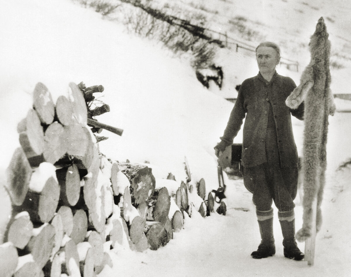 Fannie Quigley holding a wolf hide in the snow