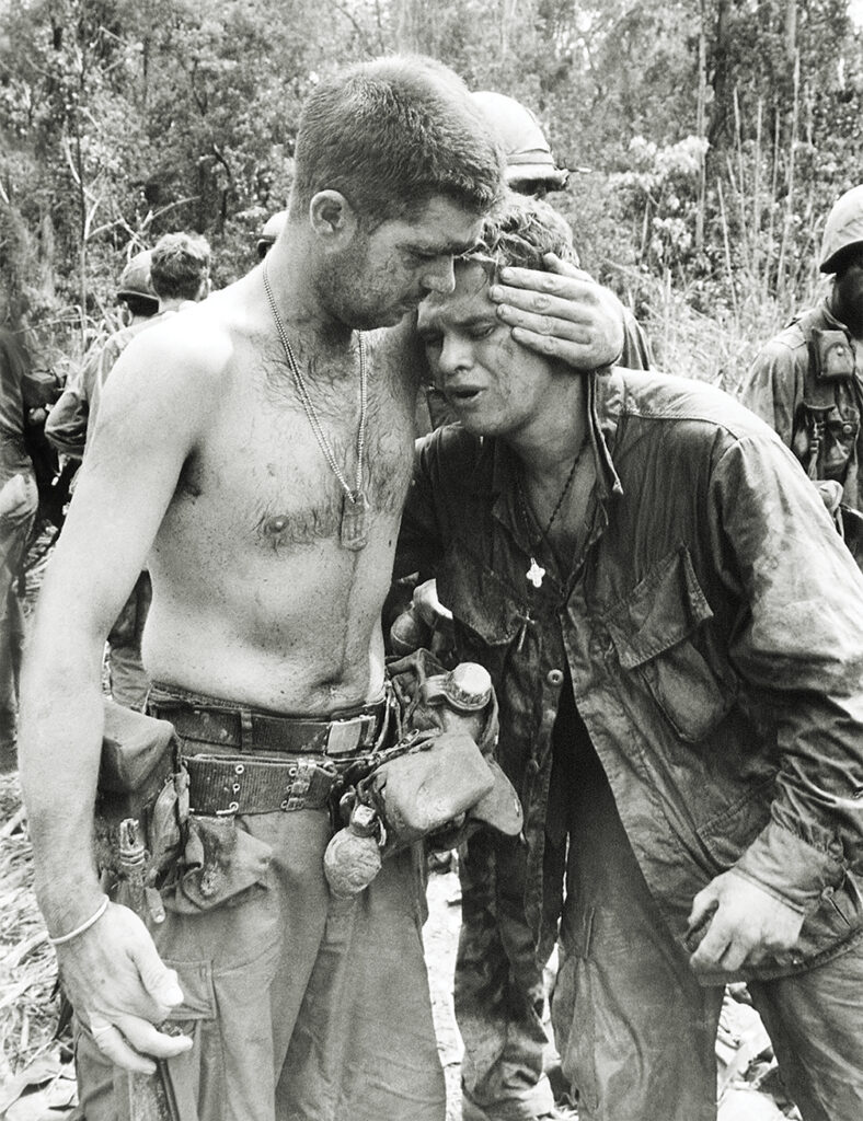 Photo of, Weeping uncontrollably, an American infantryman is comforted by a fellow GI after surviving a battle with the North Vietnamese in the Central Vietnamese highlands near the Cambodian border in Vietnam on May 21, 1967. He was with a 6-man patrol that watched the enemy set up an attack that killed 16 Americans and wounded 79 others. The patrol’s radio jammed preventing them from warning their fellow soldiers.