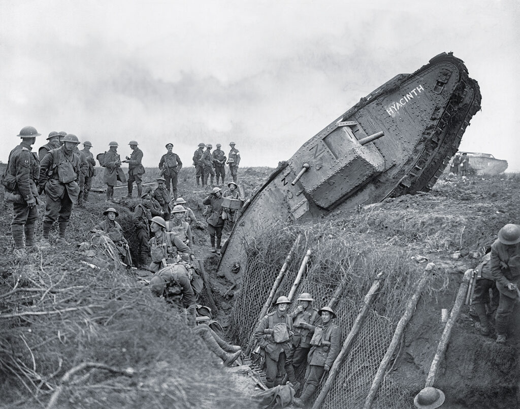 Photo of The Battle Of Cambrai 20-30 November 1917, A Mark IV (Male) tank of H Battalion ditched in a German trench while supporting the 1st Battalion, Leicestershire Regiment, one mile west of Ribecourt. Some men of the battalion are resting in the trench, 20 November 1917.
