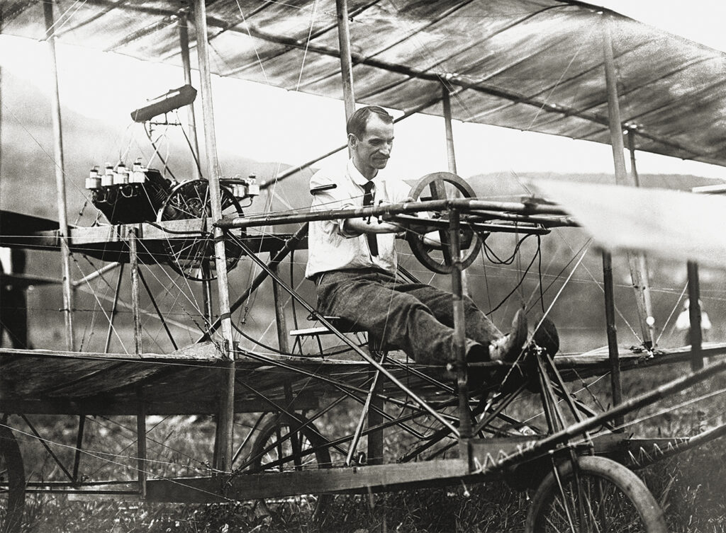 Photo of Glenn Curtiss sitting in the "June Bug" aeroplane.