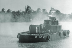 Photo of Crewmen on board the Monitor, a "battleship" of the U. S. Navy's River Assault Force, fires 40 mm shells toward enemy positions in a jungle during recent operations in the Mekong Delta. The concept of riverine operations dates back to the U. S. Civil War and was used to divide the South in that conflict. In Vietnam, the Monitor is part of a flotilla which provides support to U. S. ground combat troops.