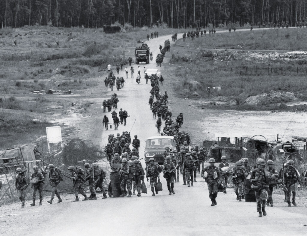 Photo of South Vietnamese paratroopers move along Route 13 as reinforcements for the fighting taking place north of Saigon near the Cambodian border on April 8, 1972. The troops are moving on foot, clearing the way for re-supply convoys on the road leading to the provincial capital An Loc.