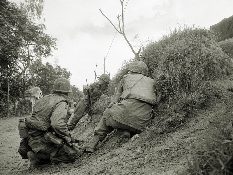 Photo of three American advisers, who had to abandon the Quang Tri base camp 19 miles south of the DMZ in face of enemy offensive, crouch in ditch for protection against incoming North Vietnamese Artillery. The soldiers were making their way to nearby city of Quang tri, South Vietnam on April 3, 1972.