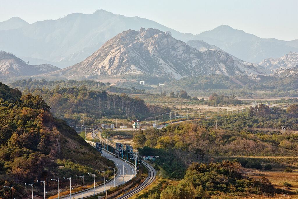 Photo of the road leading into the Korean DMZ in eastern Korea, and the Diamond (Kuemgang) Mountains (in North Korea) in the background.
