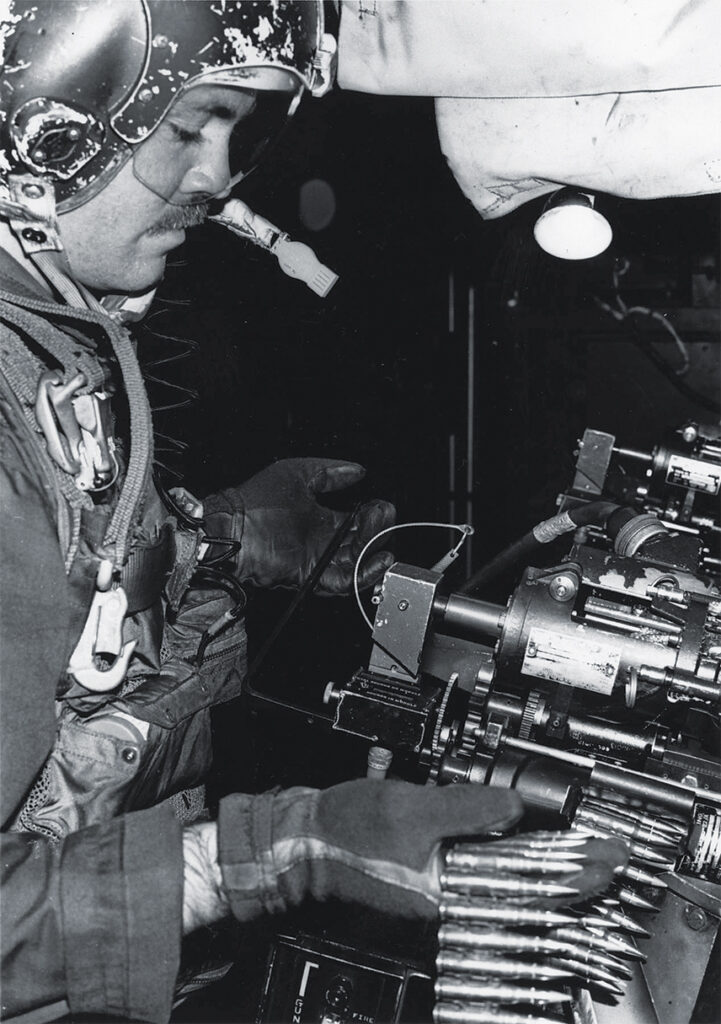 Photo of 7.62 MM MINIGUN: SSgt Harry R. Watters loads 1500 rounds into one of the gunship's four miniguns. Each gun had a firing rate of up to 6000 rounds per minute.