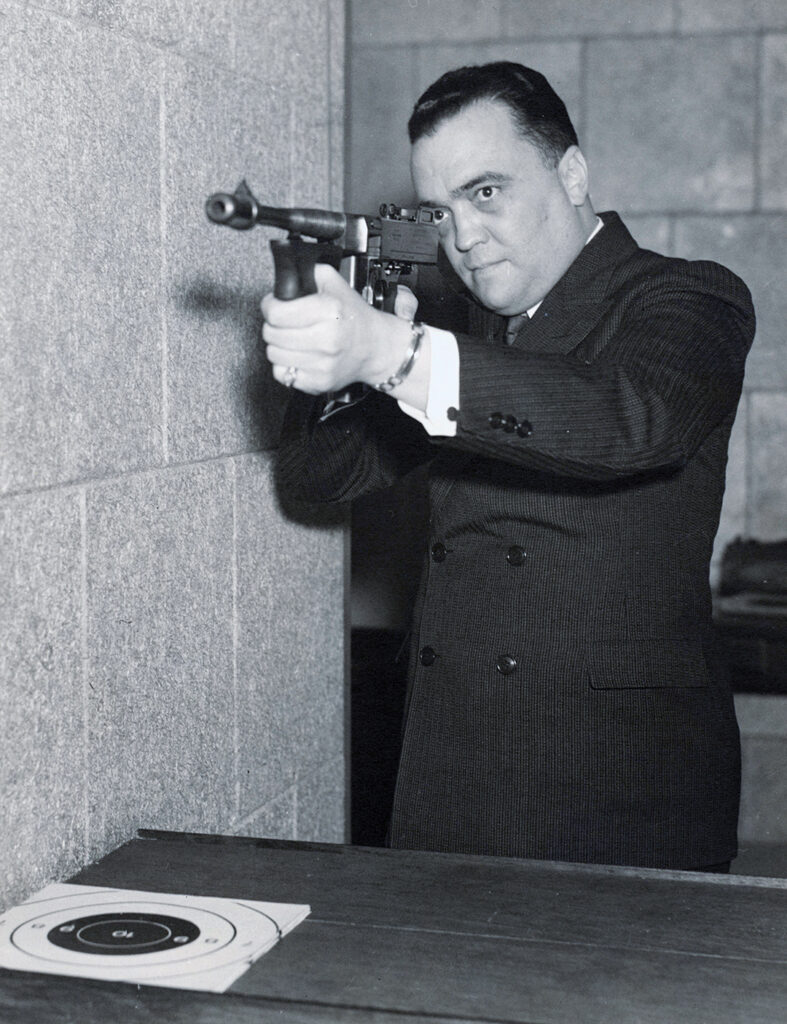 J. Edgar Hoover, pictured with a Thompson submachine gun.