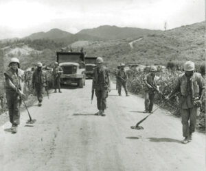 Photo of a Marine mine sweep team checks a road west of Ca Lu for enemy mines in 1968, a duty performed every morning.