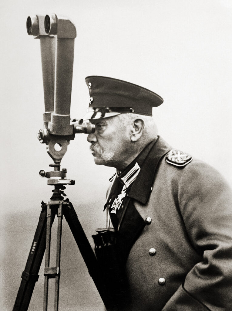 Photo of Fieldmarshal Paul von Hindenburg, supreme commander of German forces during the second half of World War One, peering through a periscope, circa 1917.