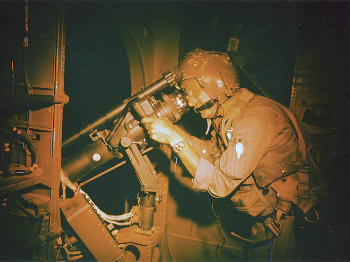 Photo of William Dawson of the 71st Special Operations Squadron trains his AC-119’s night observation scope during a mission in April 1969.