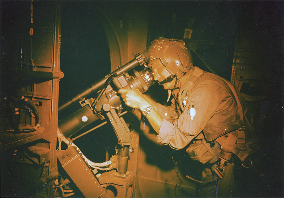 Photo of William Dawson of the 71st Special Operations Squadron trains his AC-119’s night observation scope during a mission in April 1969.