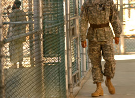 A U.S. Army Soldier stands guard as a detainee spends time in the exercise yard outside Camp Five at the Joint Task Force Guantanamo detention center on Naval Base Guantanamo Bay, Cuba, Nov. 14, 2006 (U.S. Army photo by Staff Sgt. Jon Soucy). 