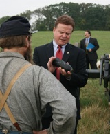 Senator Jim Webb examines a rifled artillery shell on the Third Winchester Battlefield.