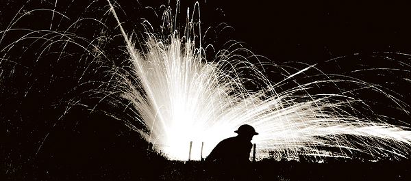 An exploding phosphorous round silhouettes a helmeted American doughboy of the 28th Division at Fismette in August 1918. The French-ordered attack was a costly failure. (National Archives)