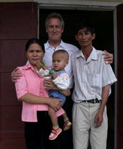 On a trip back to My Lai in 2008, Larry Colburn embraces Do Hoa, the boy he helped rescue from a ditch in 1968, and his family. (copyright Michael Bilton)