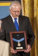 Richard Etchberger with his father's Medal of Honor. (Defense Dept. Photo)