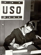 A solider at a USO writing center in WWII. Cell phones and Skype have ushered in a new era.